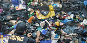 Indonesian customs official examines Australia's contaminated plastic waste at Batam port. 