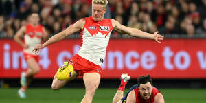 Isaac Heeney gets a kick away for the Swans.