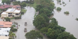 Woman clings to tree,family escape as flooded creek flips car