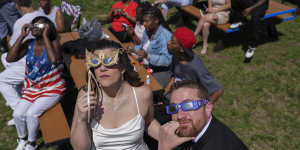 Samantha Palmer,left,and Gerald Lester watch a total solar eclipse before getting married during the event in Trenton,Ohio.