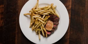 The bavette steak comes pink and glistening inside,and darkly crusty outside,smothered in skinny,skin-on fries.