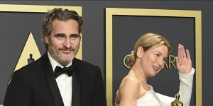 Joaquin Phoenix and Renee Zellweger pose in the press room with their Oscars.