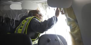A National Transportation Safety Board investigator examining the fuselage plug area of Alaska Airlines Flight 1282.
