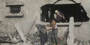 Palestinians evacuate a building damaged in the Gaza Strip. 
