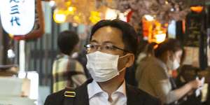 A man walks through the Shinjuku area of Tokyo as COVID cases surge in Japan. 