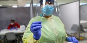 A healthcare worker holds a swab sample at the COVID-19 rapid test facility at Fiumicino Airport in Rome.
