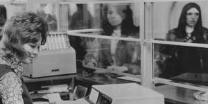 A bank teller uses a Chequemaster machine,designed for cashing cheques and handling savings withdrawals,in 1972.
