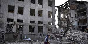 A resident clears debris near a building damaged in the Russian air raid in Orikhiv,Ukraine.