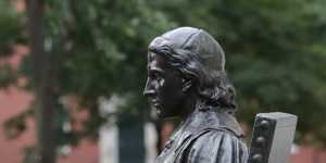 A statue of John Harvard sits in Harvard Yard at Harvard University.