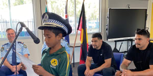 Latrell Mitchell and Cody Walker with police officers and a pupil from Cabbage Tree Island Public School.
