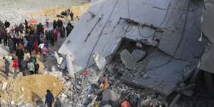 Palestinians look at the destruction after an Israeli strike on a residential building in Rafah,Gaza Strip on Friday.
