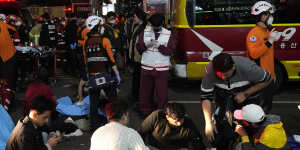 Rescue workers and firefighters try to help injured people.