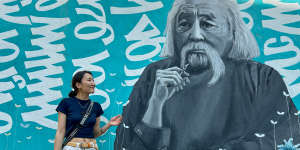 Zolzaya Nyamdorj,a coordinator at Save the Mongolian Language movement,in front of a mural of scholar Renchin Byamba. 
