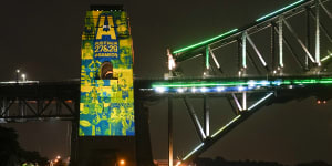 Sydney ferries sail past the illuminated pylon of the Sydney Harbour Bridge on Thursday night.