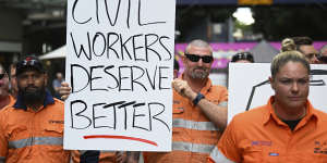 Striking CFMEU members,who work on the Albert Street Cross River Rail construction site,hold signs outside the site this week.