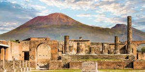 Ancient walls in Pompeii with volcano Vesuvius in the background.