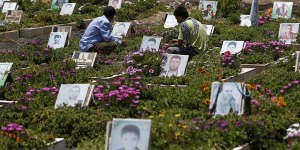 Shiite rebels,known as Houthis,pray at portrait adorned graves of Houthi fighters in Sanaa last week.