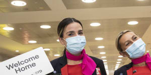 Qantas staff welcome people arriving at Sydney International Airport on Monday morning.