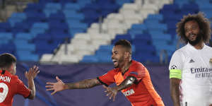 Shakhtar's Manor Solomon celebrates after scoring his side's third goal as Madrid's Marcelo Vieira looks on.