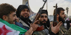 Syrian opposition fighters celebrate after the government collapsed in Damascus on Sunday.