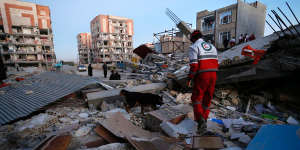 A Red Crescent rescue worker searches for survivors with his sniffing dog in Sarpol-e-Zahab in western Iran.