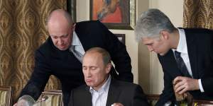 “Putin’s chef”:Yevgeny Prigozhin,left,serves food to Russian Prime Minister Vladimir Putin during a banquet in 2011.