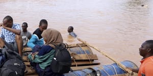People cross a flooded area on makeshift raft in north-east Kenya in November.