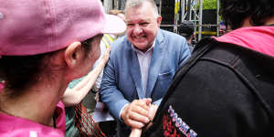 Former Liberal MP Craig Kelly shakes hands with a protester at the rally. 