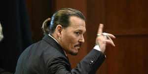 Actor Johnny Depp gestures as he walks out of the courtroom.