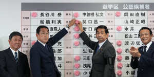 Fumio Kishida,second left,Japan’s prime minister,placing a red paper rose on an LDP candidate’s name,to indicate a victory in the upper house election,at the party’s headquarters in Tokyo.