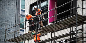 Workers are seen taking down cladding ahead of the first view of the North Sydney Metro.