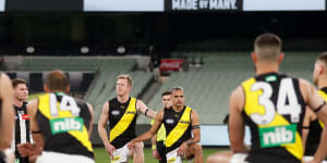 Players and umpires take the knee in support of the Black Lives Matter movement before the match between Collingwood and Richmond.