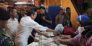 Indonesian President Joko Widodo greets people at Pal Merah traditional market,in Jakarta.
