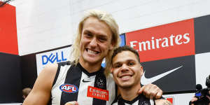 Skipper Darcy Moore celebrating with small forward Bobby Hill in the Collingwood rooms after the win over Melbourne. His right wrist and thumb were strapped for the game.