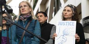 Sarah Kuhnen,in blue,and other"Justice for Justine"activists outside the Minneapolis courtroom this week.