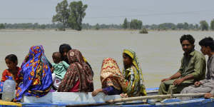 In Pakistan in August,displaced people travel floodwaters that followed an extreme monsoon season.