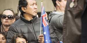Spectators show their respects during the ANZAC Day march in Melbourne.