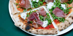 Downtown pizza with tomato,fior di latte,prosciutto,truffled stracciatella and rocket.