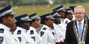 Prime Minister Scott Morrison inspects an honour guard of the Royal Solomon Islands Police Force after arriving at Honiara International Airport.