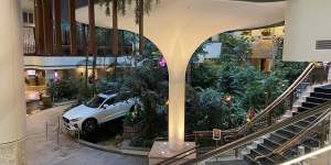 An $87,000 Volvo,a prize in a lottery,sits among fake greenery in the atrium.