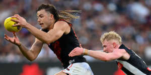 Essendon’s Sam Draper is tackled by Collingwood’s John Noble. 