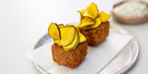 Crumbed and fried pig's head terrine topped with zucchini pickles.