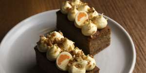 Carrot cake is topped with architectural cream cheese swirls.
