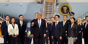 Trump fist pumps after touching down in Beijing.