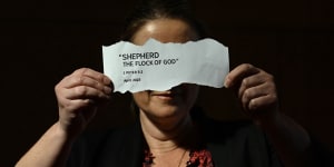 A former Jehovah’s Witness holding a tear out of the 2023 handbook titled “Shepherd The Flock of God”.