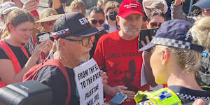 Mark Gillespie is warned by police for brandishing a sign reading “from the sea to the river” while Parry fronts court.