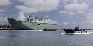 HMAS Adelaide with a landing craft.