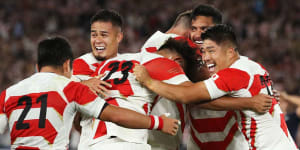 Japan's players celebrate after beating Scotland to progress to the Rugby World Cup quarter-finals.