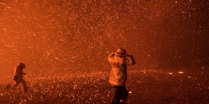 Firefighters run for safety as the Green Wattle Creek fire explodes into a sudden ember storm in Orangeville in December 2019,as captured in this award-winning photo by Nick Moir.