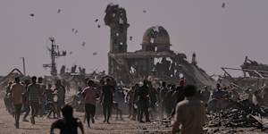 Palestinians collect leaflets dropped by an Israeli drone warning people to stay away from the so-called yellow line in Khan Younis,in the southern Gaza Strip,Monday,Oct. 20,2025. (AP Photo/Jehad Alshrafi)